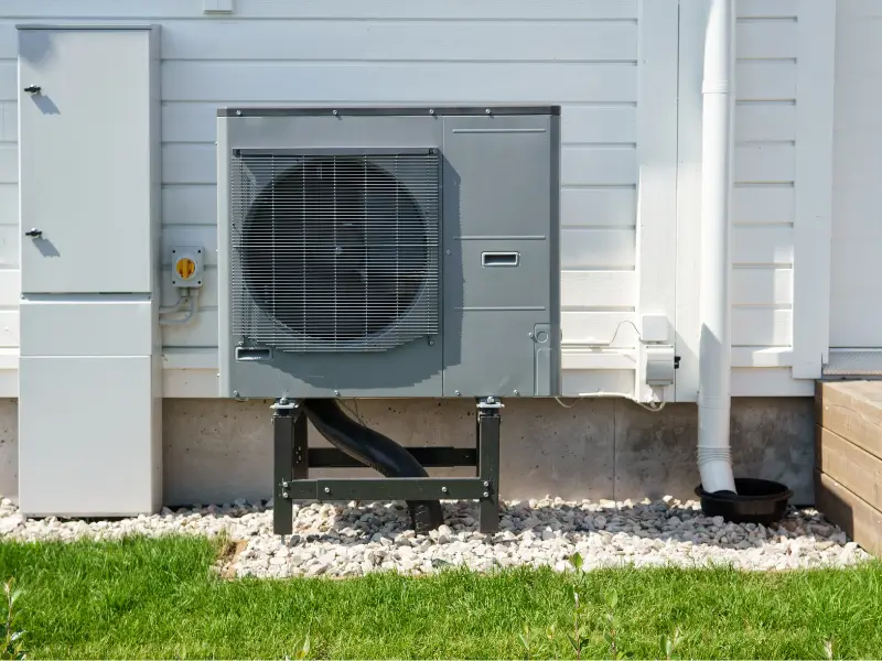 Luft-Luft-Wärmepumpe an der Außenseite eines holzverkleideten Hauses.