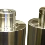 Close-up view of two polished metal rollers with central shafts.