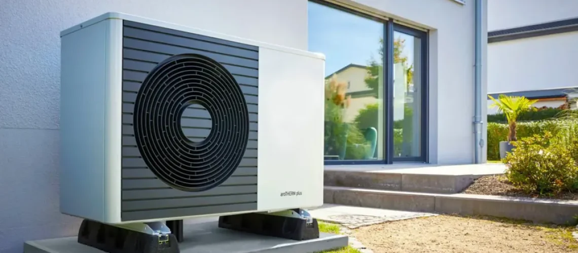 Outdoor installation of a Vaillant aroTHERM plus air-to-water heat pump unit against a brick wall.